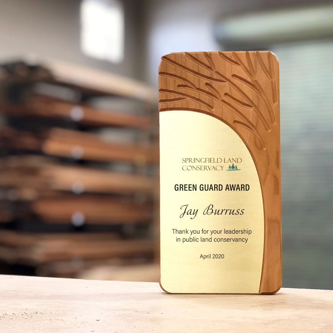 FSC Cherry Arbor Award (Rivanna original) with engraved tree motif, shown in a workshop with stacked wood in background.
