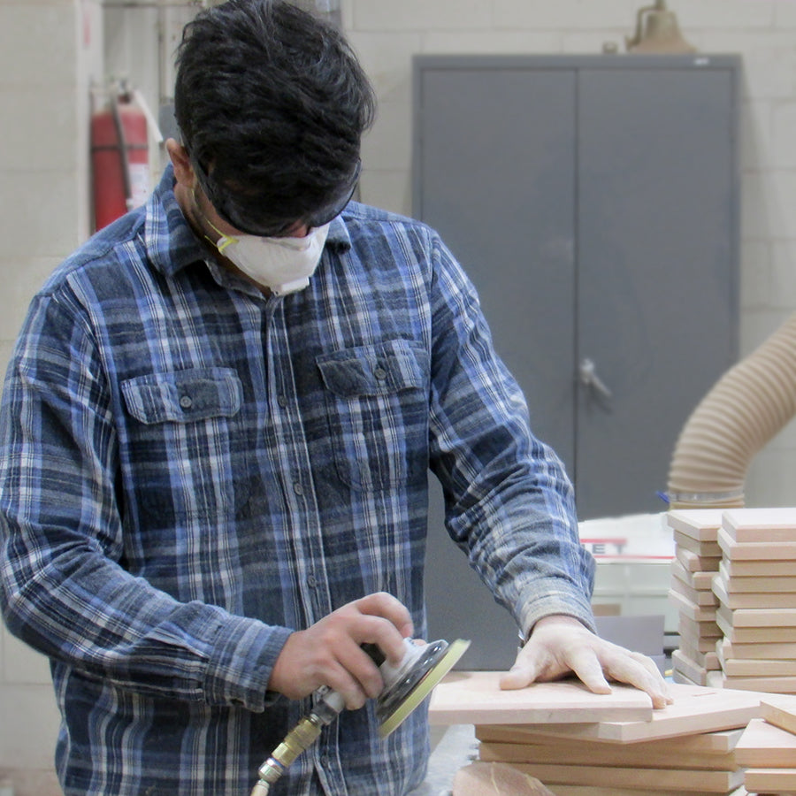 Rivanna team member sanding FSC-certified cherry awards in our Virginia woodshop.