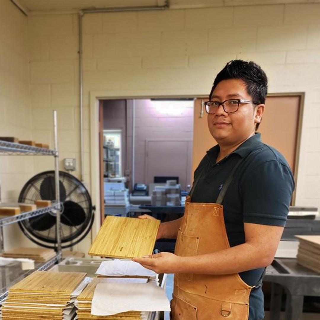 A Rivanna team member with a stack of finished bamboo plaques in our Virginia facility.