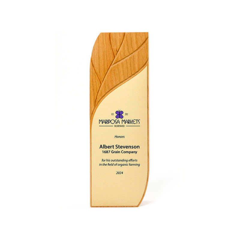 Sustainable trophy with a carved leaf on top. FSC Natural Cherry. Sustainable.