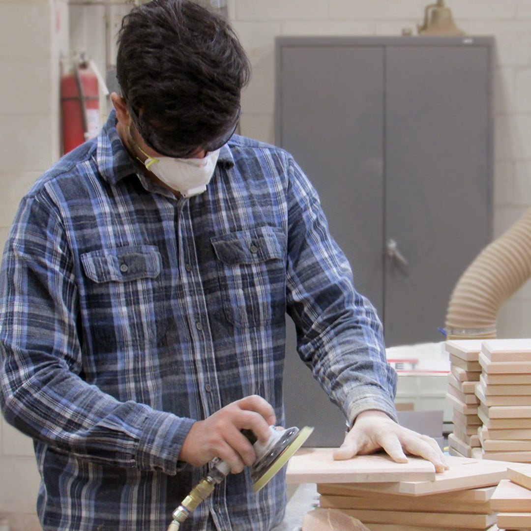 A Rivanna team member sands an FSC-certified wooden award component in our Virginia woodshop.