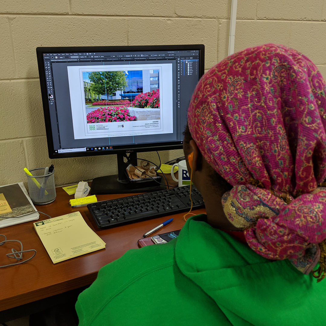 A Rivanna designer finalizes award artwork using Adobe Illustrator on a desktop computer.