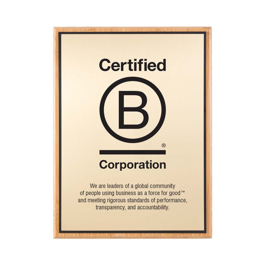 Certified B Corporation bamboo plaque featuring logo and engraved mission statement on a satin gold plate.