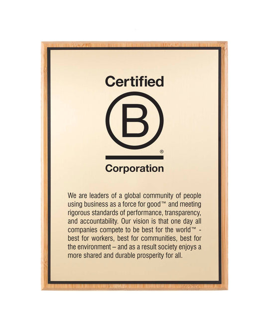 Certified B Corporation bamboo plaque with full engraved mission and vision text on a gold aluminum plate.