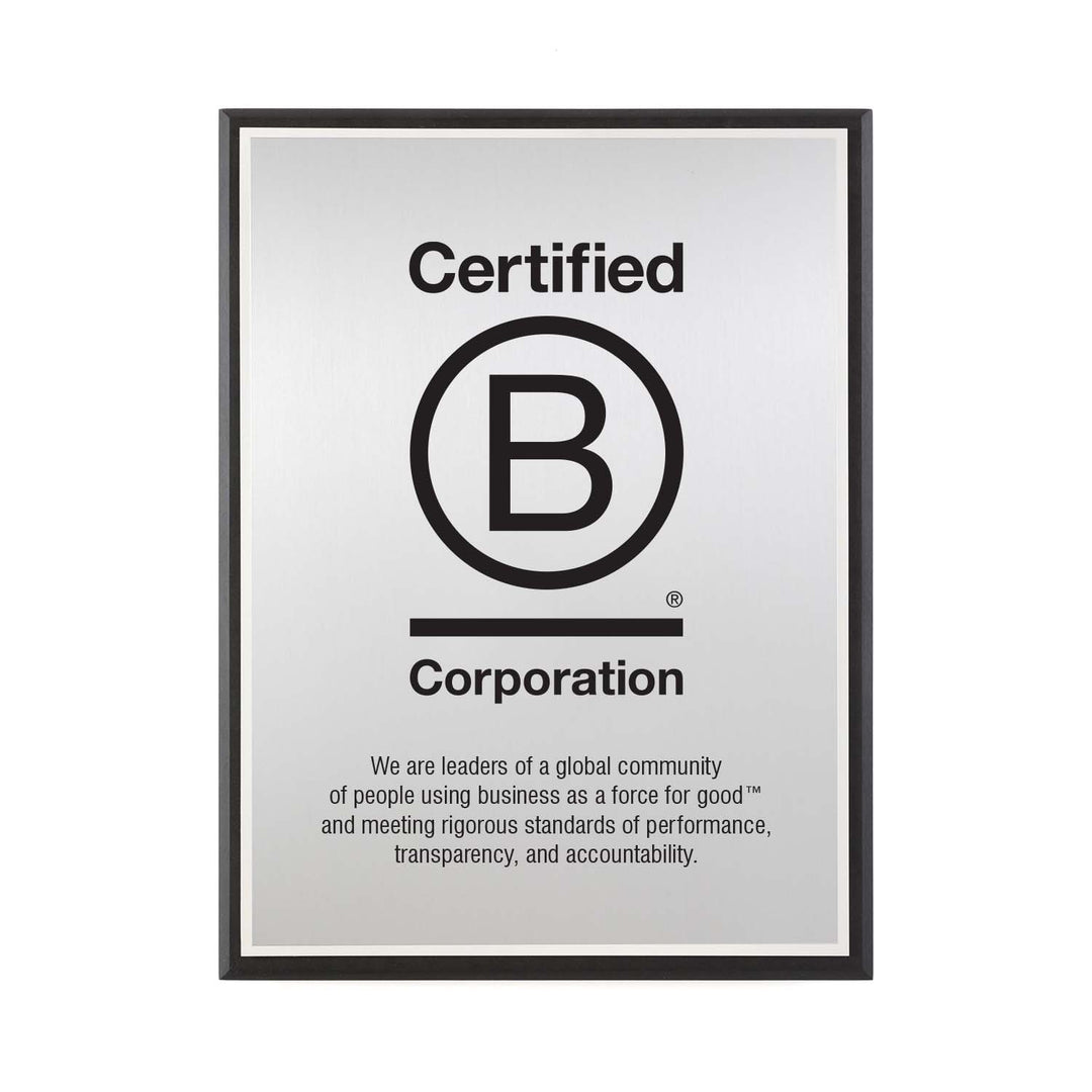 B Corporation silver plaque with logo and engraved mission statement, framed in recycled black Richlite.
