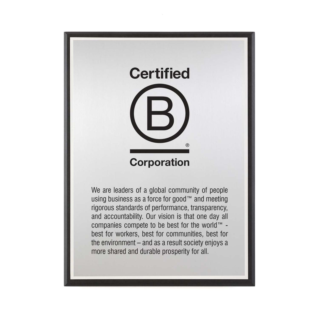 Certified B Corporation silver plaque featuring full mission and vision text, set on recycled black Richlite.