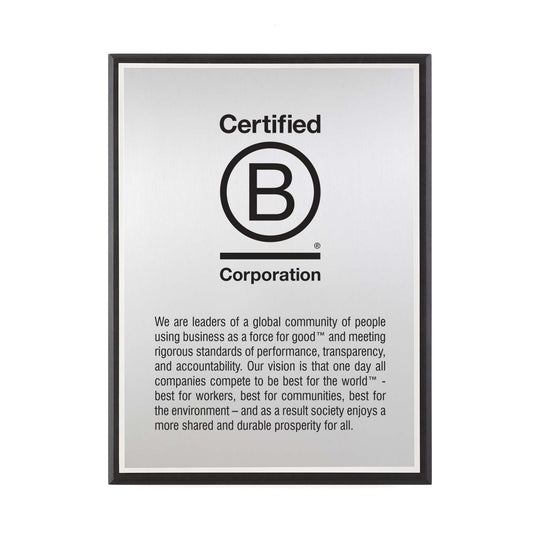 Certified B Corporation silver plaque featuring full mission and vision text, set on recycled black Richlite.
