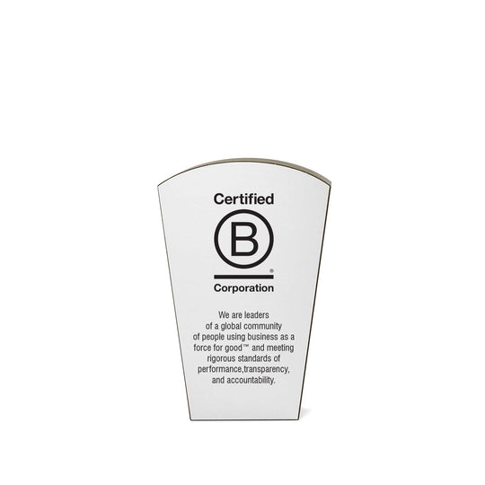 Recycled black  B Corporation award with  logo on silver metal and mission statement about using business as a force for good.